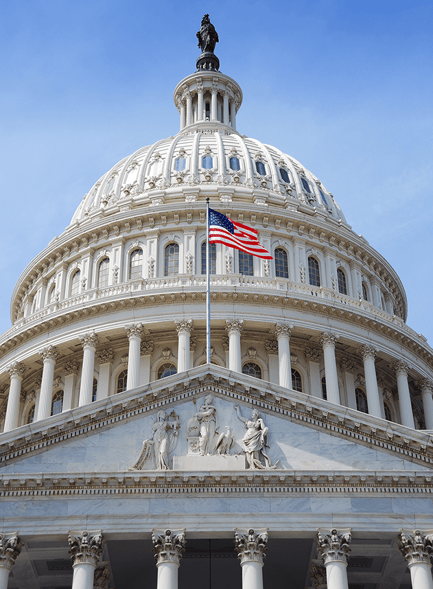 The United States Capitol building dome with an American flag in front, viewed from below against a clear blue sky, makes a striking image perfect for your homepage or v2 cloned website design.