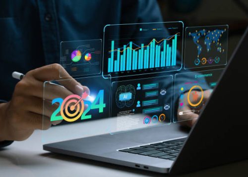 Businessman works on laptop Showing 2024 business trends dashboard with charts, metrics,  AI, E-commerce, KPI. analytical businessperson planning business growth 2024. New Year Future business tech.